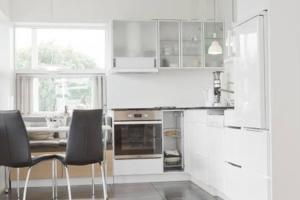 a kitchen with white cabinets and a table and chairs at City center, Tórshavn in Tórshavn