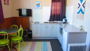 a kitchen with a table and chairs in it at Mountain Jade Backpackers,Private Rooms & Studios in Hokitika