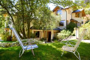 two chairs sitting in the grass in front of a house at Matices Patagonicos in San Carlos de Bariloche