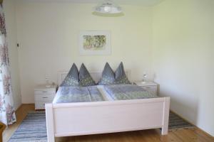 a white bed with blue pillows in a bedroom at Ferienwohnungen Benedikt in Villach