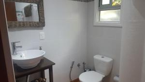 ein weißes Badezimmer mit Toilette und Waschbecken in der Unterkunft Cabaña I Punta Negra in Piriápolis