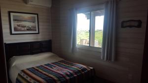 a bedroom with a bed and a window at Cabaña I Punta Negra in Piriápolis