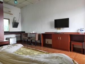 a room with a bed and a tv on a desk at CHONG TI HOTEL in Dili