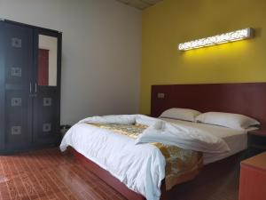 - une chambre avec un lit et une lumière sur le mur dans l'établissement CHONG TI HOTEL, à Dili