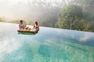 
two people sitting on a raft in the water at Kamandalu Ubud - CHSE Certified in Ubud
