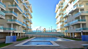 - une piscine en face d'un bâtiment avec une aire de jeux dans l'établissement Anacasa Blaumar Mediterranea AP760, à Piles