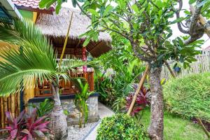 a garden with trees and plants in front of a house at Rama Homestay in Nusa Penida