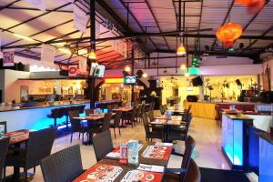 a restaurant with tables and chairs and a bar at Legian Paradiso Hotel in Legian