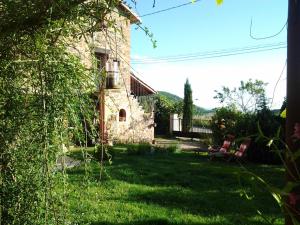 an outside view of a stone house with a yard at Le Clos du Merle in Savigny