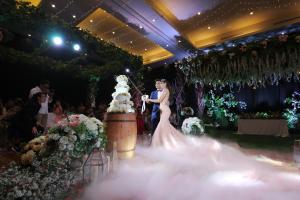 
a bride and groom cutting their wedding cake at Golden Palace Hotel Lombok in Mataram
