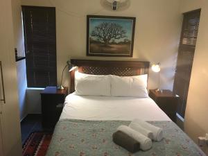 a bedroom with a bed with two towels on it at A Little Guesthouse in Bloemfontein