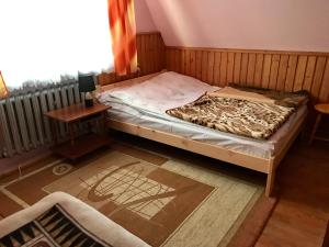 a bedroom with a bed and a table and a window at Pokoje Gościnne in Bukowina Tatrzańska