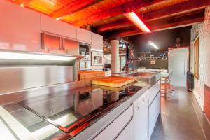 a large kitchen with stainless steel counter tops at Ca Carmela Casa con Encanto cerca del Garbi con piscina, solo buenas vibraciones!!! in Valencia