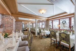 ein Restaurant mit weißen Tischen und Stühlen und Fenstern in der Unterkunft Hotel Madeleine in Obergurgl