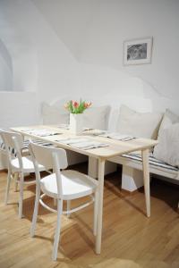 City Center Apartment في فيينا: طاولة طعام بيضاء وكراسي مع أريكة