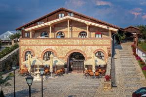 a large brick building with umbrellas in front of it at Conacul Maria Theresa in Orlat