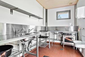 a kitchen with stainless steel appliances and a stove at Omme Å Camping & Cottages in Sønder Omme