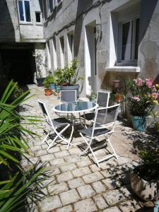 a patio with a glass table and two chairs at boyard in Rochefort