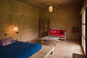 Cette chambre comprend un lit, un canapé et une table. dans l'établissement Lisu Lodge, à Mae Taeng