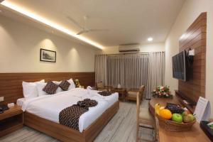 Habitación de hotel con cama y mesa con TV en Hotel Anjali Park, en Kottayam