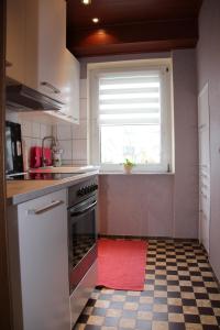 a kitchen with a red towel on the floor at Ferienwohnung am Gipsberg in Merzig +17 photos