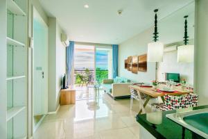 a kitchen and living room with a table and a couch at Atlantis Condo Resort Jomtien TLH in Jomtien Beach