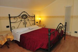 sypialnia z dużym łóżkiem i czerwonym kocem w obiekcie Locanda Sant'Anna Hotel w Wenecji