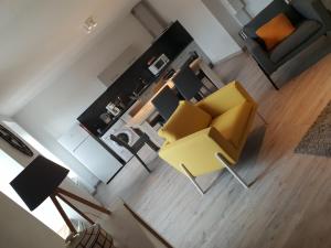 Saint-AnthèmeAPPARTEMENT ROUGE的享有带黄椅的客厅的顶部景色