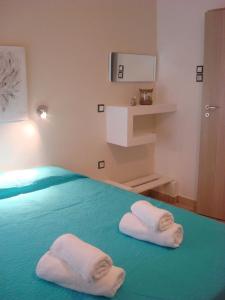 two white towels sitting on a bed in a room at Smaragdi Studios and Rooms in Agios Kirykos