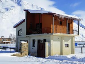 a house with snow on top of it in front of a mountain at ---Allegria House--- in Kazbegi
