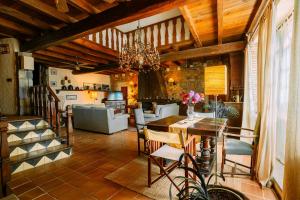 a dining room and living room with a chandelier at Can Vila in Sant Julià del Llor