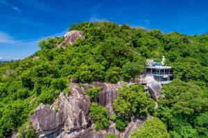 a building on top of a mountain with trees at Deishaview Jungle Hostel in Ko Tao