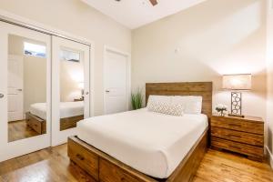 a bedroom with a large white bed and a mirror at Spacious Lofts Close to French Quarter & Bourbon St. in New Orleans