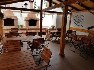 ein leeres Restaurant mit Holztischen und -stühlen in der Unterkunft Mar-Mari's in Eforie Nord