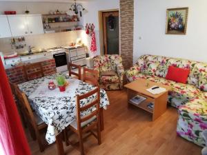 a living room with a table and a kitchen at Apartment Resman in Tršće