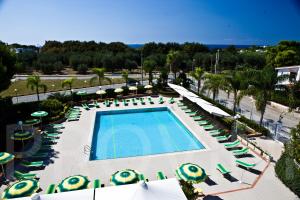 uma vista superior para uma piscina com cadeiras e guarda-sóis em Residence Atlante em Leporano