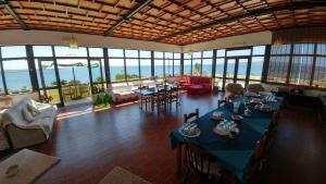 a large room with tables and chairs and windows at Villarolu in Portoscuso