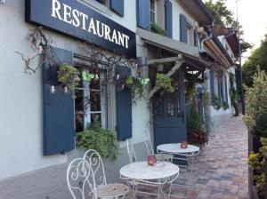 two tables and chairs in front of a restaurant at La Maison d'Artgile in Zimmersheim