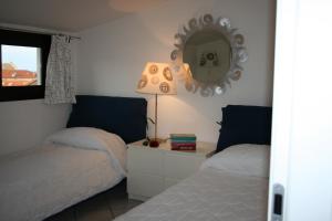 a bedroom with two beds and a mirror on the wall at a 100 metri dal mare in Diano Marina