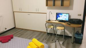 a room with a desk with a computer and a bed at Studio CENTRAL 1 in Aosta