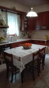 una cocina con una mesa con un bol de fruta. en Alkantara Holiday, en Francavilla di Sicilia