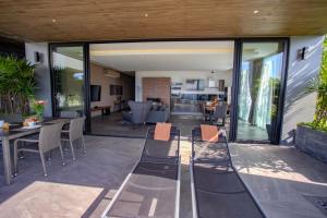 a patio with glass doors and chairs and a living room at Ocean Rock Kalim in Patong Beach