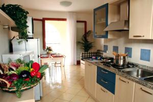 Villaggio Orchidea في بيبيوني: مطبخ مع حوض ومكتب مع وعاء من الخضروات