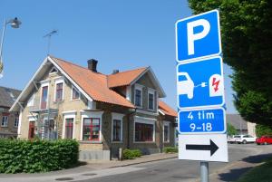 una señal azul de estacionamiento frente a una casa en Åhus B&B och Vandrarhem, en Åhus