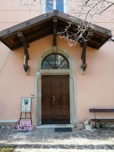 un perro tirado frente a una puerta de madera en Ca' antica, en Rovereto