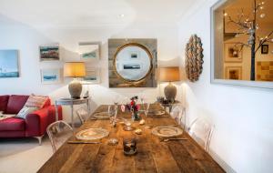 een eetkamer met een houten tafel en een rode bank bij Stunning home with breathtaking sea views in Penzance