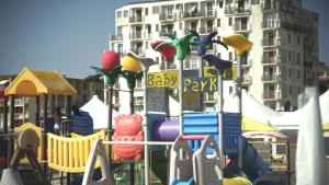 a playground with colorful play equipment in front of a building at Villetta Marfisa in Lido di Spina