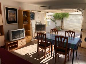 ガンディアにあるResidencial El L´Ullal II - Family Onlyのリビングルーム(テーブル、椅子、テレビ付)
