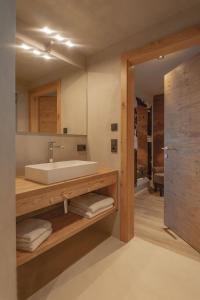 ein Bad mit einem Waschbecken und einem Spiegel in der Unterkunft Appartements Erwin & Eleonore Hüttl - Penthouse in Neukirchen am Großvenediger
