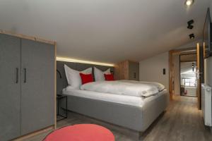 ein Schlafzimmer mit einem großen Bett mit roten Kissen in der Unterkunft Appartements Erwin & Eleonore Hüttl - Penthouse in Neukirchen am Großvenediger